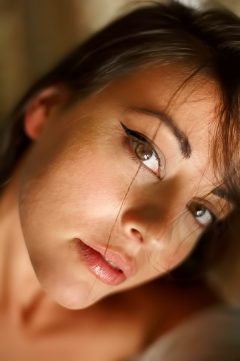 Half-naked cutie takes off stockings on cozy bed