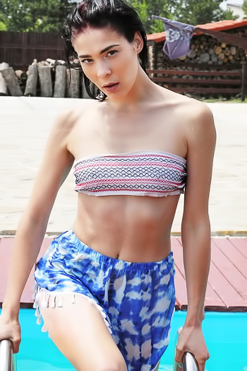 Hot brunette swims half-naked in the outdoor pool