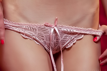 Skinny chick shows off her small tits on a red sofa